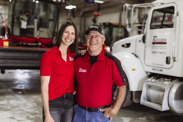 Rachelle and Ron Regier smiling together inside the Regier Equipment service bay.
